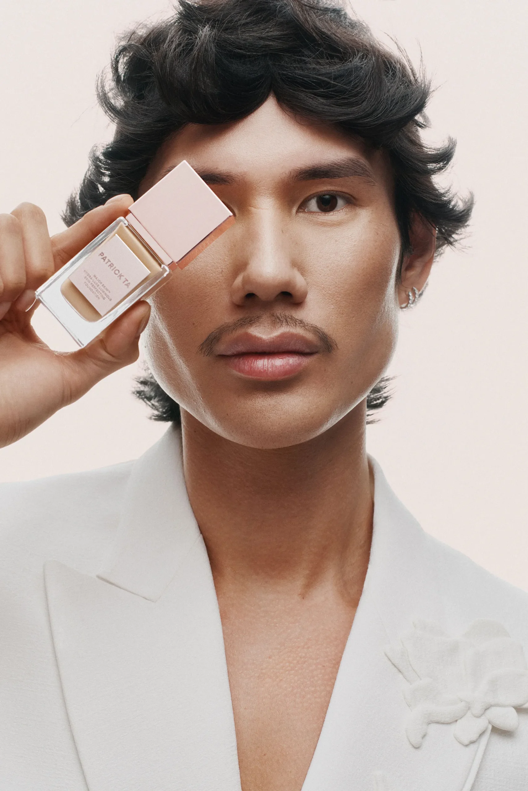 Photo of Patrick Ta holding phone up to his eye.